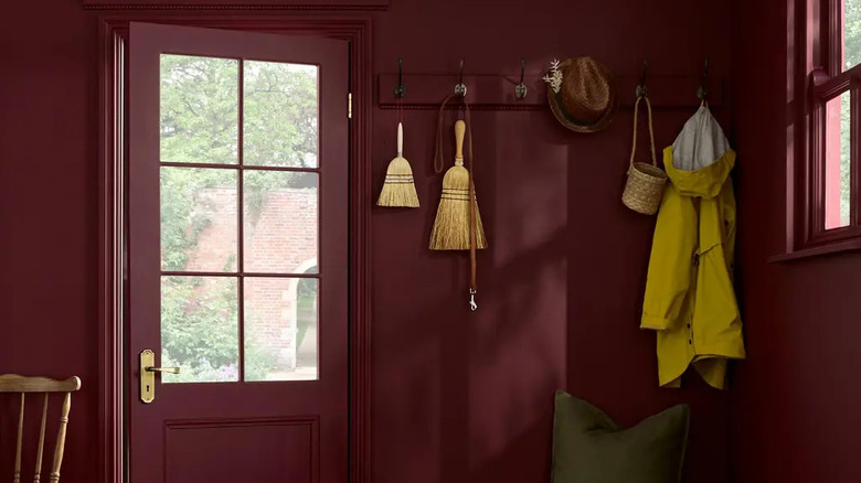 An entryway mud room with bordeaux red walls.