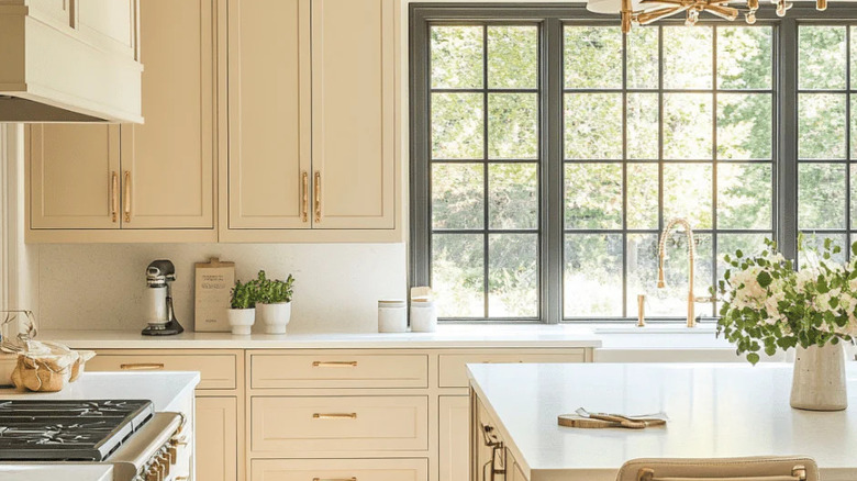A bright kitchen with beige yellow cabinets.