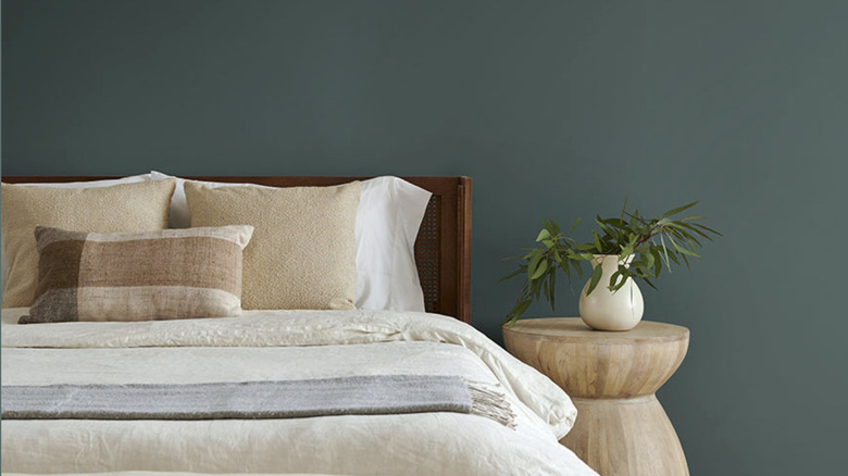 A close up on a bed with a dark blue wall.