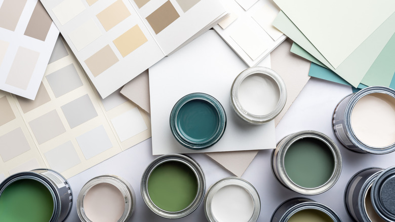Open paint cans and swatches in green and neutral shades.
