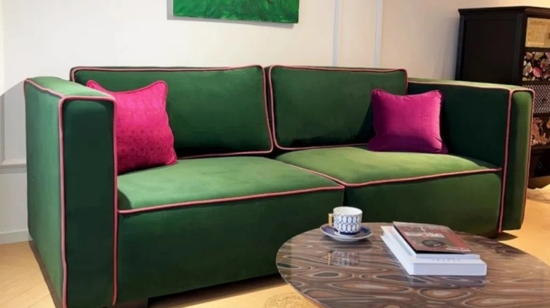 A green velvet sofa with contrast pink piping from Wayfair