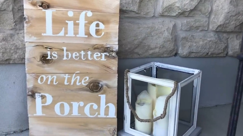 DIY lantern made from picture frames with a rope handle and candles inside