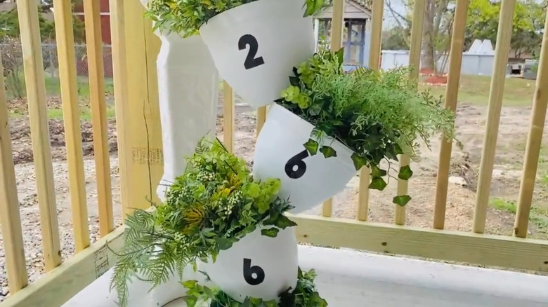 Three-tier topsy-turvy planter filled with plants and labeled with numbers