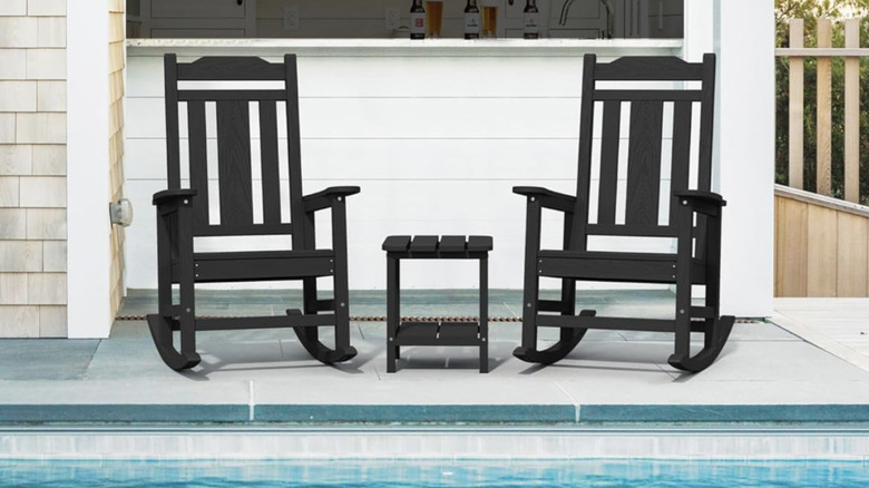 Black rocking chairs next to a swimming pool