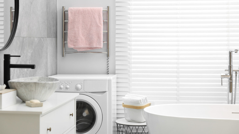 A towel warmer with a pink towel on it in the bathroom.