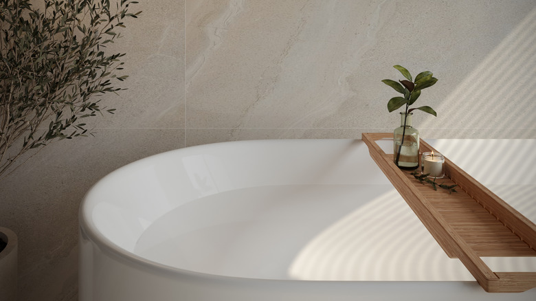 A wooden bath tray balanced on a white tub.