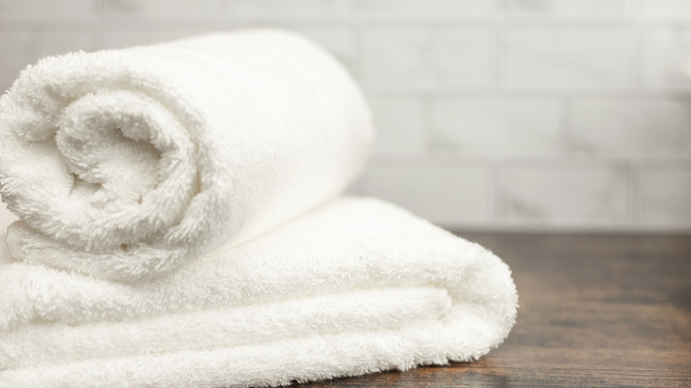 White towels rolled and folded sitting on a table.