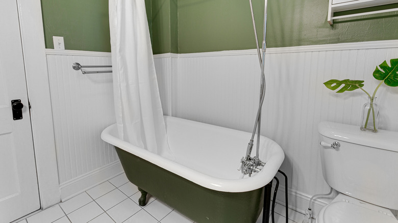 Green bathtub in white bathroom