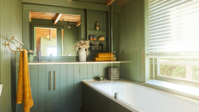 wood-paneled bathroom painted light green