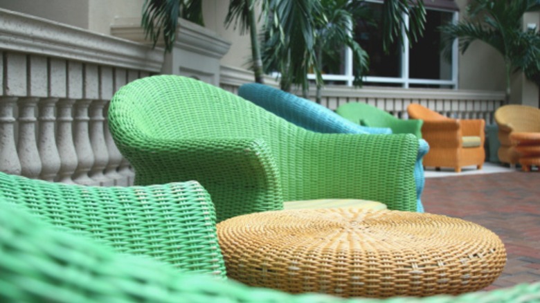 Wicker patio chairs in green, blue, and orange