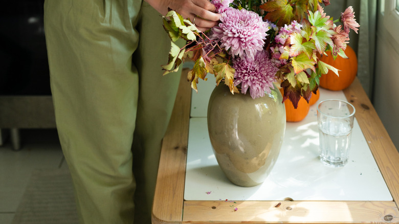 Woman arranging fresh flowers in a ceramic vase