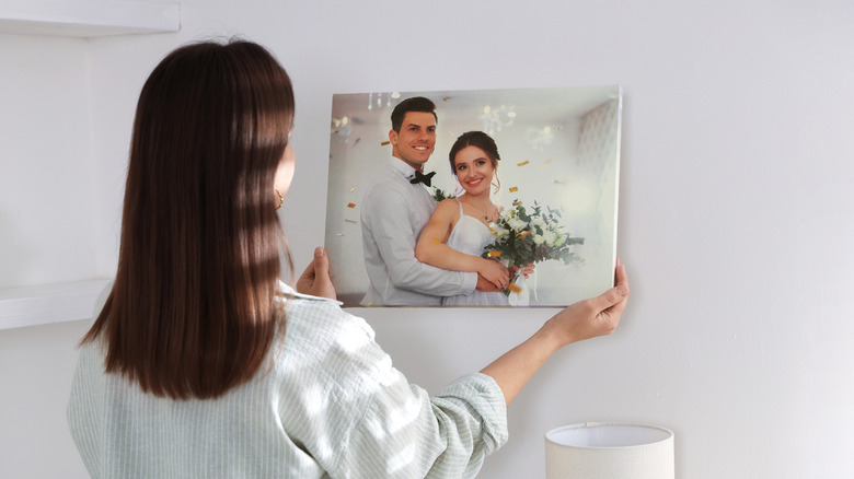 Woman hanging canvas print og on wall