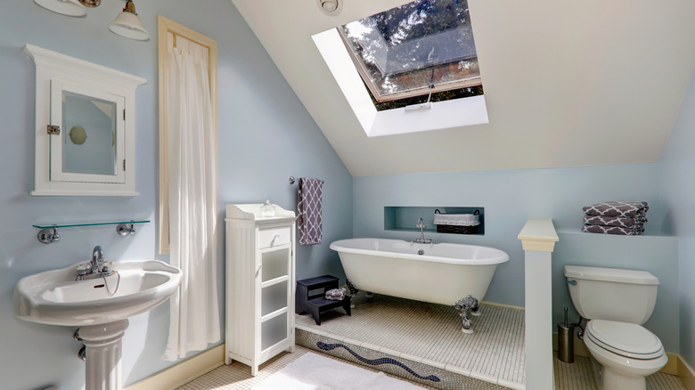 Light blue bathroom with a tub and white accents