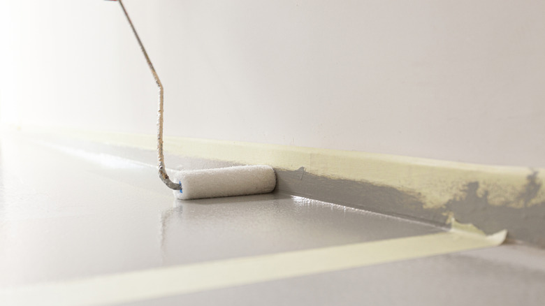 Applying clear sealer on gray floor