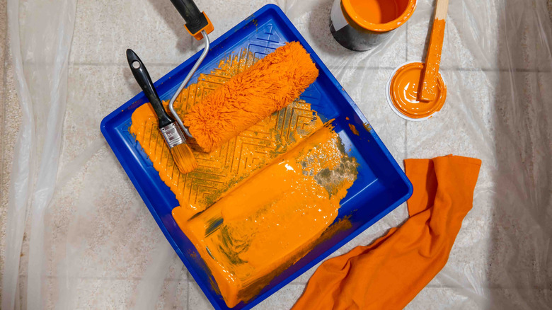 High-quality painting tools in orange paint and an orange rug