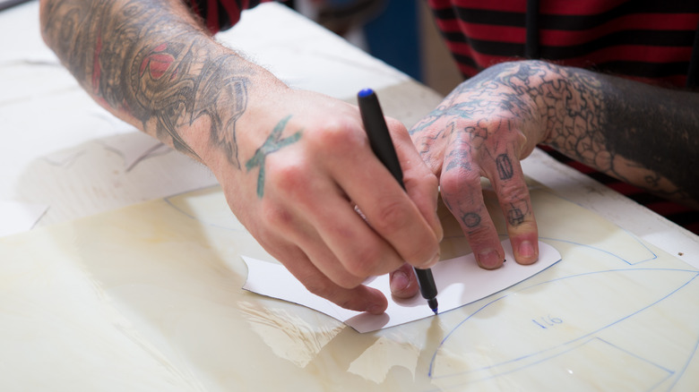 A hand drawing patterns on transfer paper