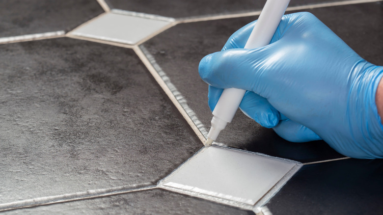 A person using a grout pen