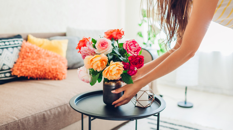 hands put out vase of fresh flowers
