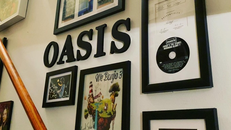 A music memorabilia wall dedicated to Oasis in a stairwell.