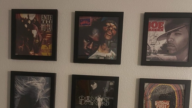 Vinyl record albums in black frames on a wall.