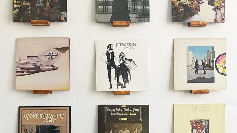 Record albums on wood blocks on a wall.