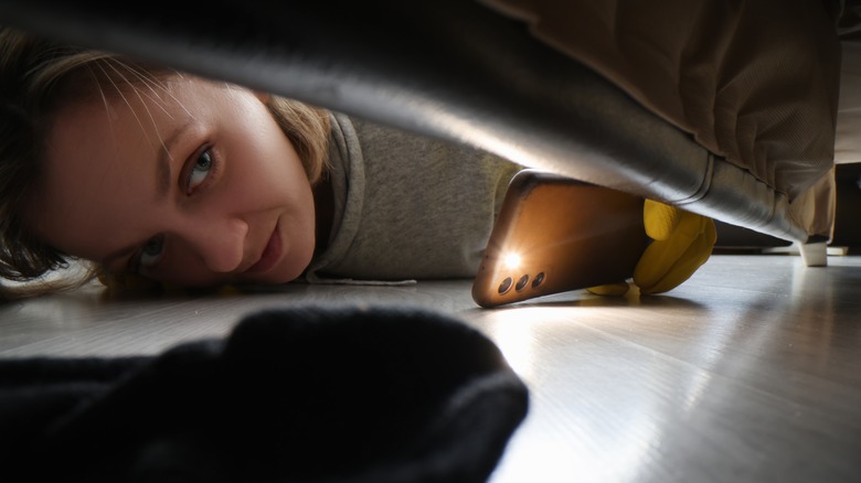 person looking under furniture
