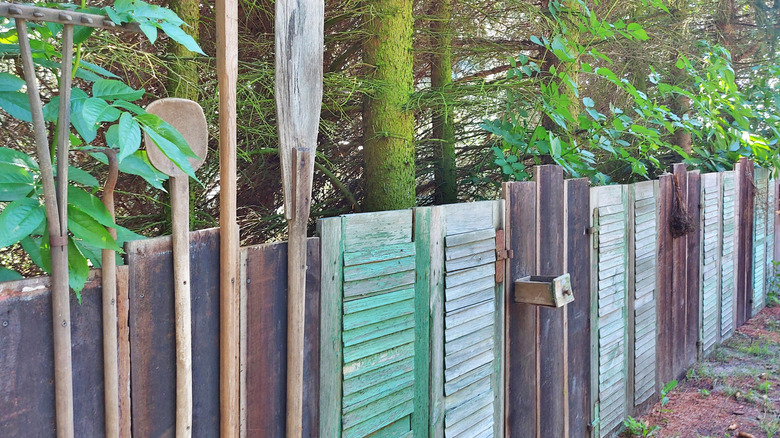 fence made from scrap wood and shutters