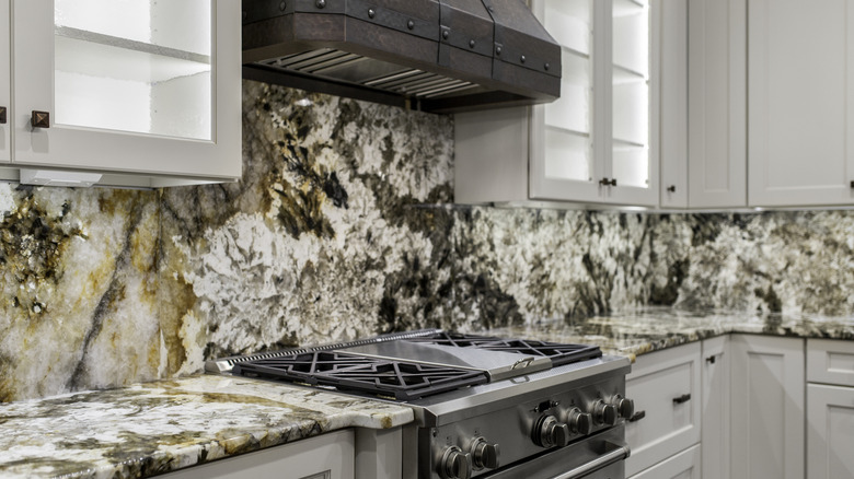 A kitchen with highly stylized granite countertop tiles and backsplashes.