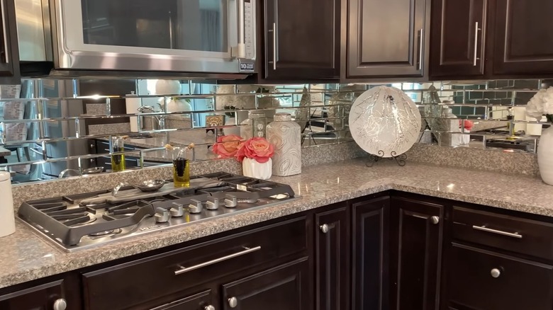 A close up of a bathroom vanity with a demi, mirror backsplash.