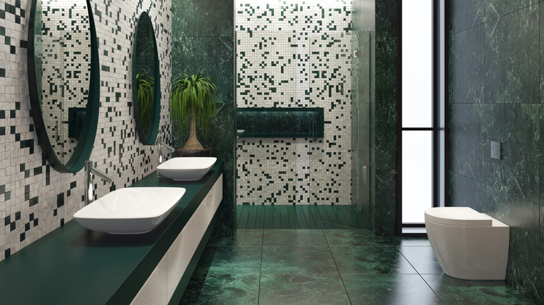 A bathroom with green accents including serpentine tile walls.