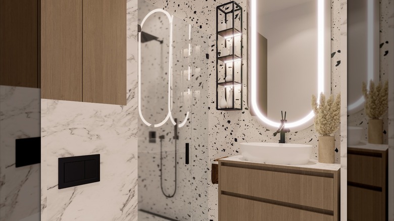 A small bathroom with a walk-in shower and terrazzo inspired walls.