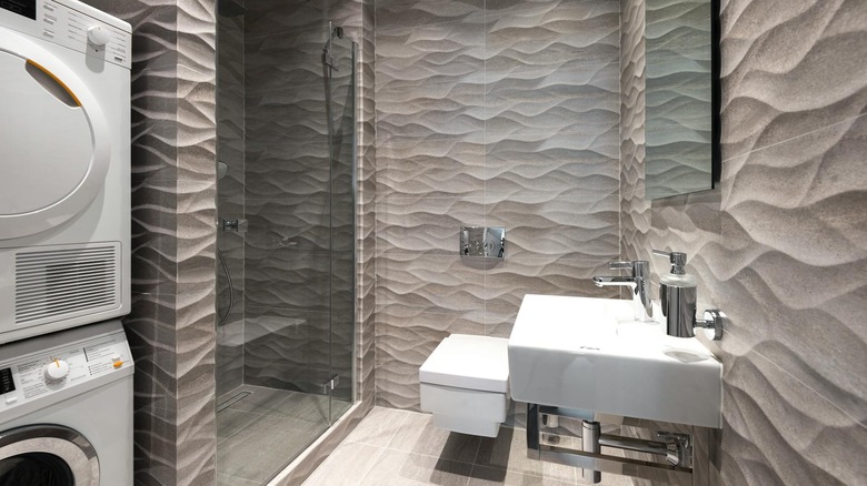 A bathroom with three-dimensional, wavy bathroom wall tiles.