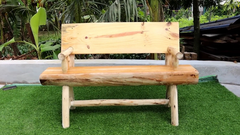 Tree stump bench on a turff surface in a back yard