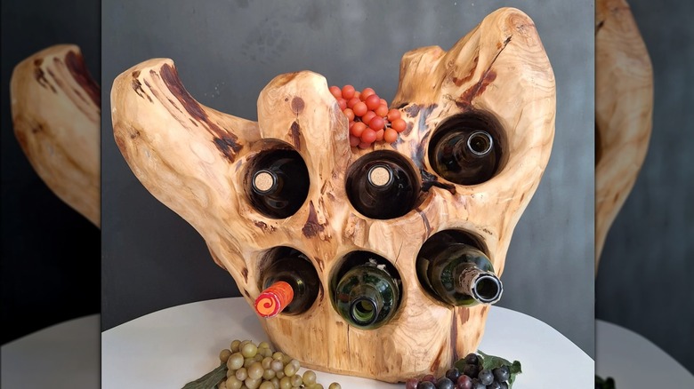 Wine bottles resting in holes drilled in a natural wood root system