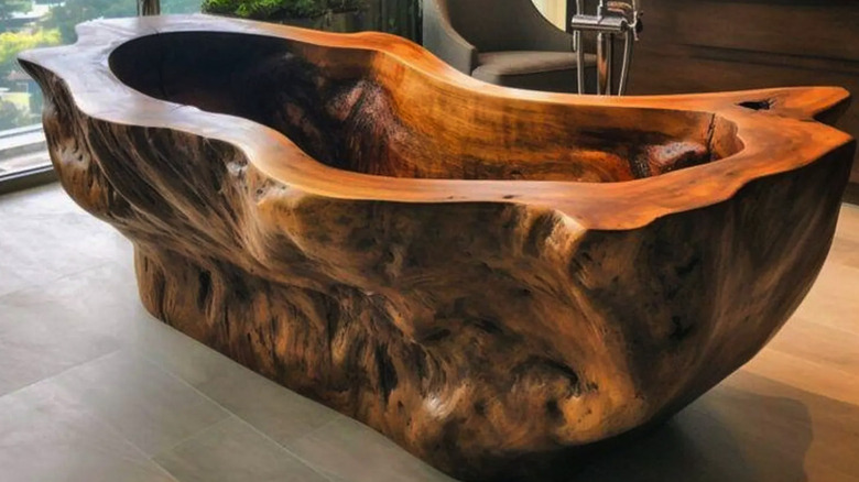 Wood bath tub filled in a modern bathroom with natural lighting