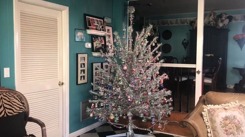 A vintage aluminum Christmas tree in a living room, decorated with vintage ornaments.