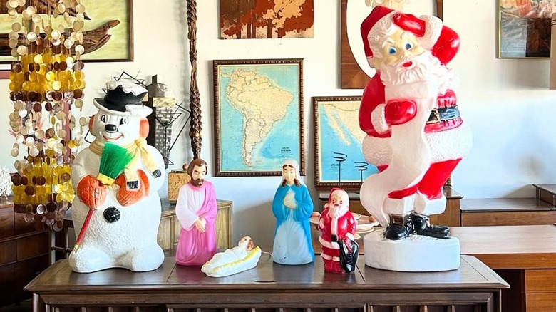 Vintage Christmas blow molds, frosty, nativity scene, and two Santas.