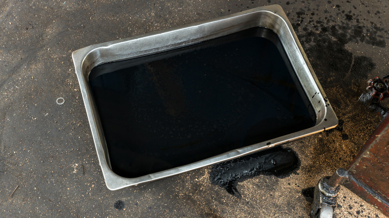 A silver drip pan filled with oil.