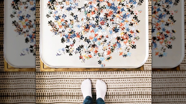 Someone standing next to a puzzle on oil drip tray.