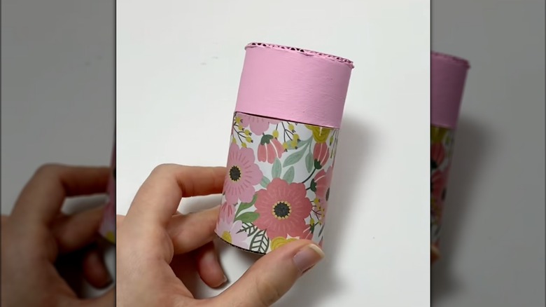 Someone holding a pink storage box.