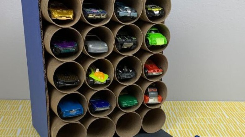 A toy car garage holding with paper rolls.