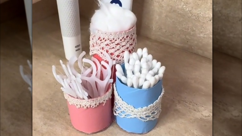 Pink-and-blue bathroom holders on counter.
