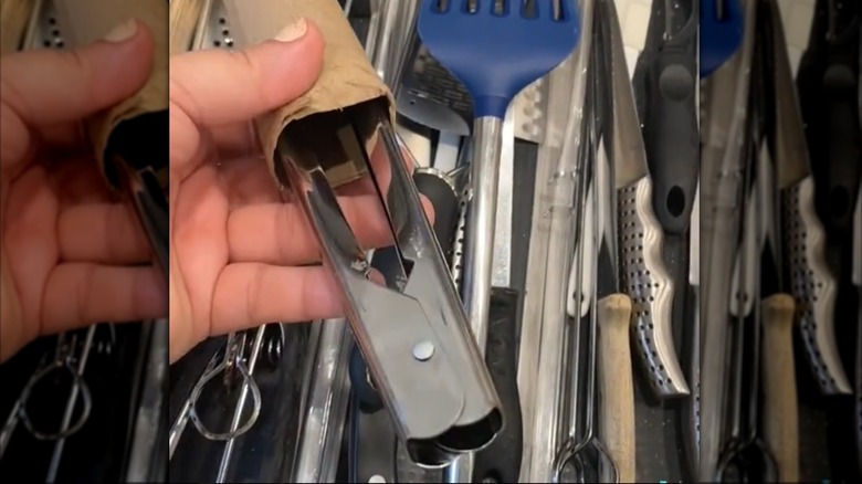 Paper rolls holding metal kitchen tongs together.