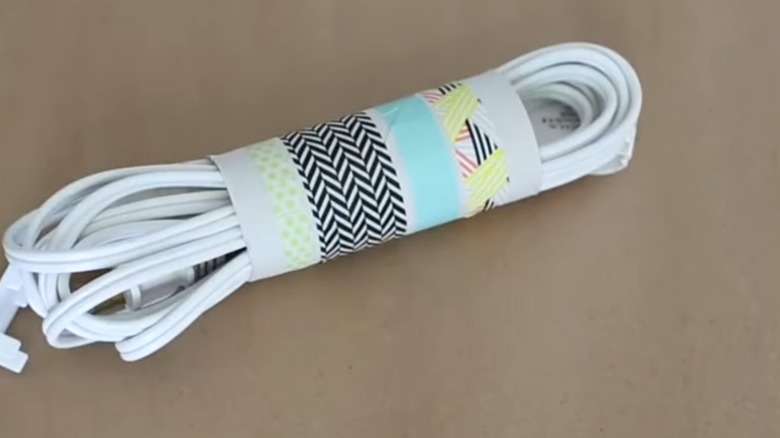 A white cord being held by a toilet paper tube.