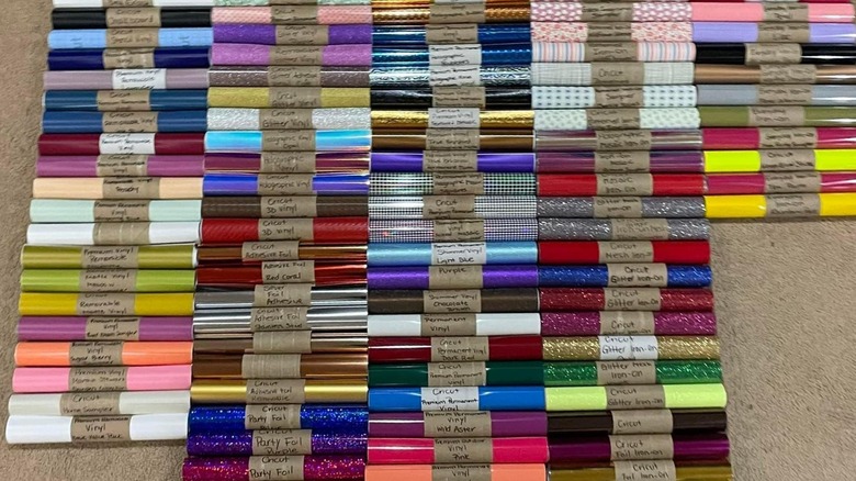 A large selection of vinyl held by toilet paper rolls.