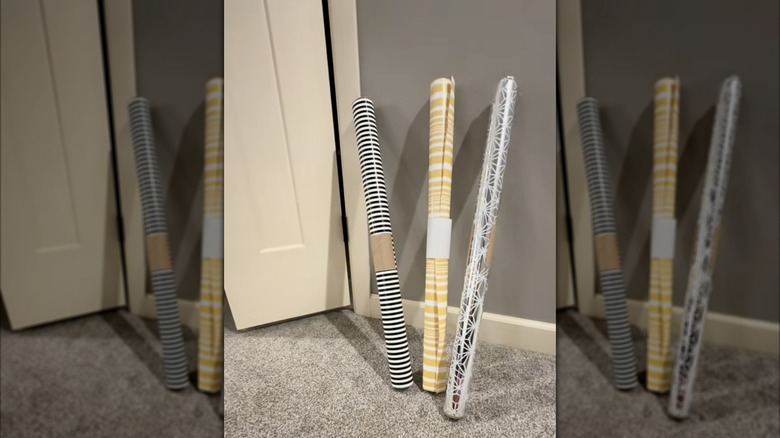 Three wrapping paper rolls held by toilet paper tubes.