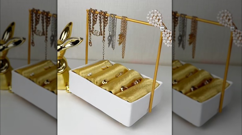 Gold-and-white jewelry box holding accessories.