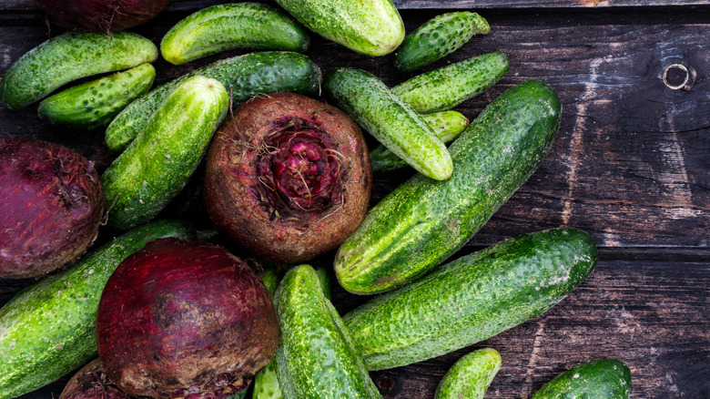 Freshly harvested cucumbers and beets placed on a wooden table