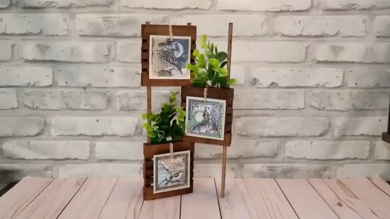 Decorative display with three mini pallets and mini clothespins displaying small artwork