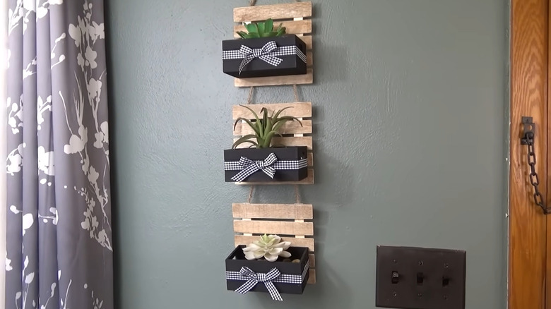 Mini pallets and wood crates attached to string to create a hanging display